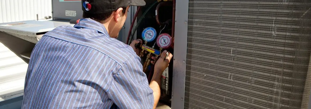 HVAC technician servicing a condenser unit in Myrtle Grove