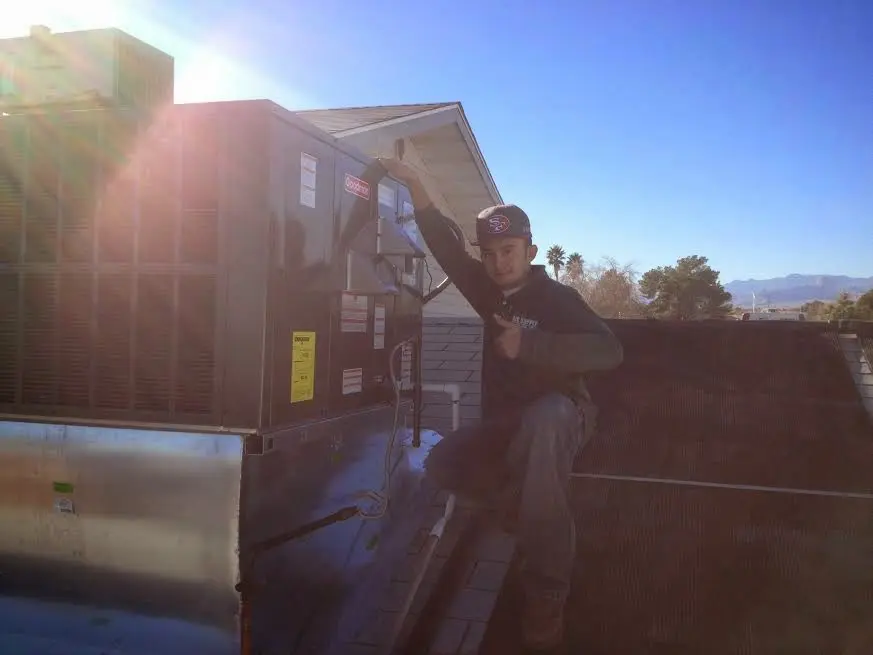 HVAC technician performing Air Duct Cleaning on a rooftop unit in Myrtle Grove
